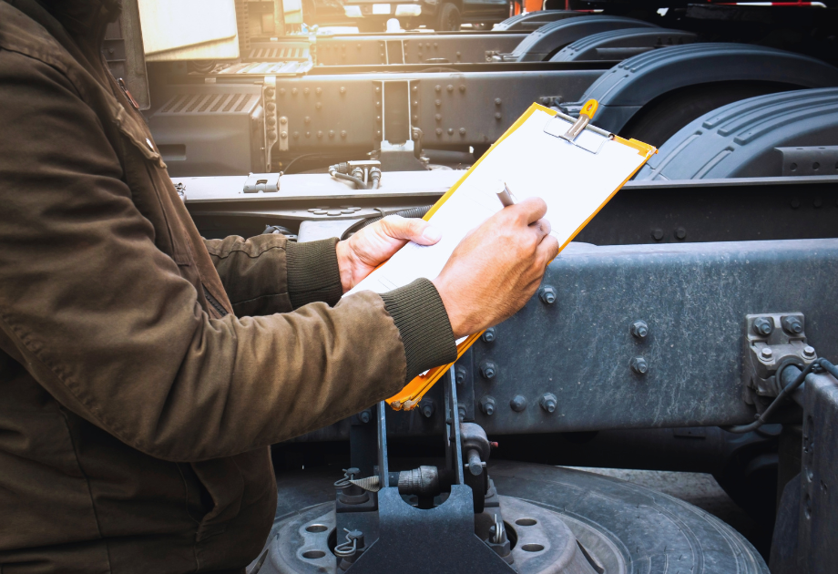 man inspecting a semi truck